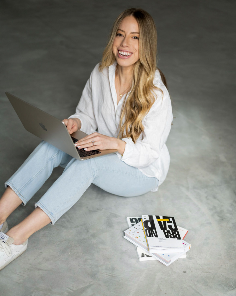 Emma Saltd Studio smiling with laptop and books