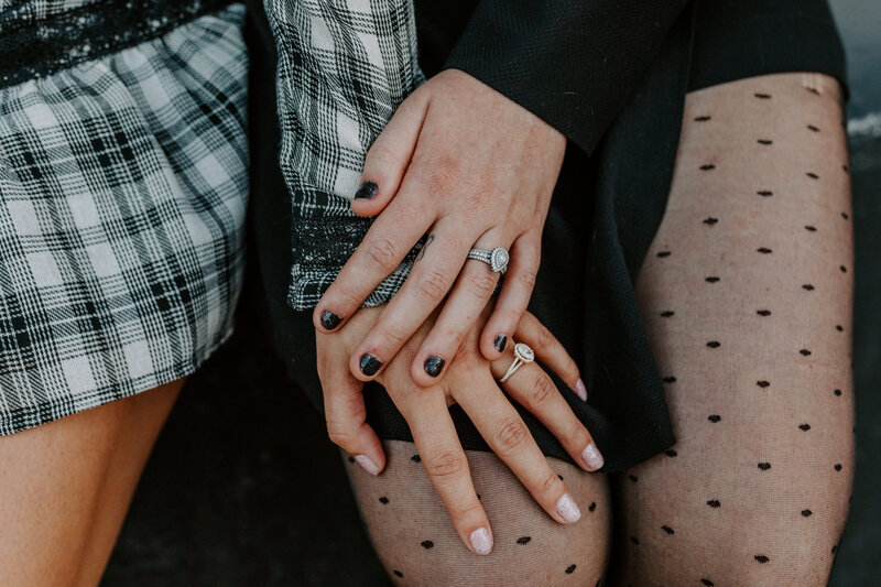 close up of two women's hands with their engagement rings on
