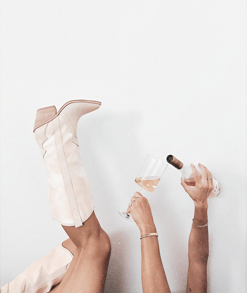 Photo of Cowboy boots and champagne celebrating business success.