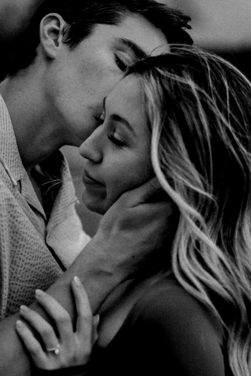 A man kissing his significant other on the cheek as she closes her eyes at Dawson Butte Open Space Colorado. 