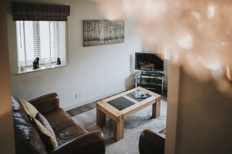 Baldry's Cottage Lounge showing couch, table and TV