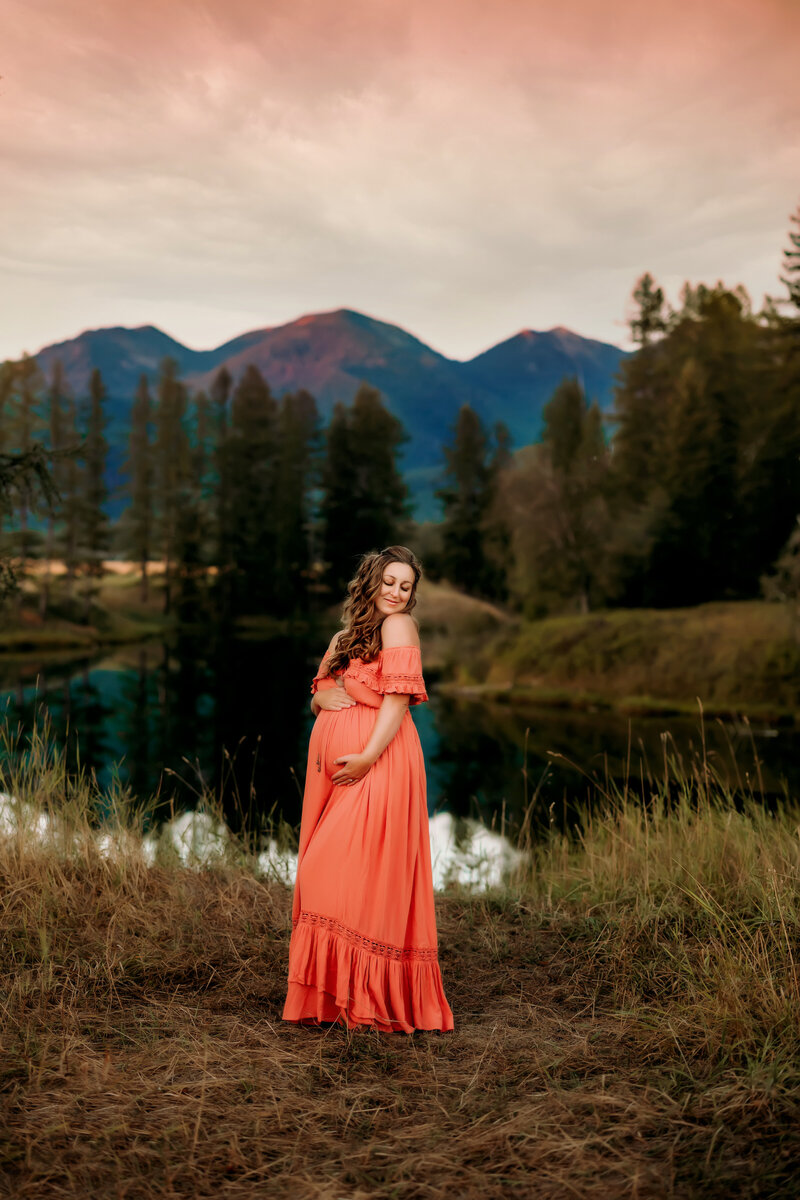 whitefish maternity photographer woman posing by flathead river