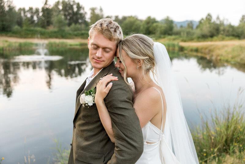 couple embracing after their wedding ceremony by the lake at olson mansion