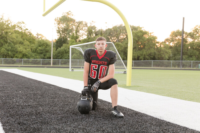 Senior boy in his football uniform in front of a goalpost