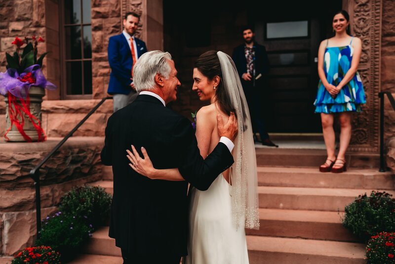 A bride & her father share an emotional embrace at a historic Erie mansion wedding, captured in a moody & timeless style.