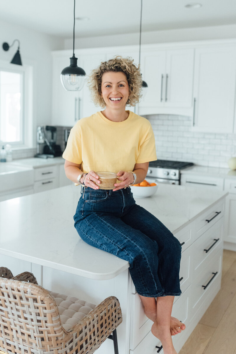 owner of eat play say sitting on counter drinking coffee