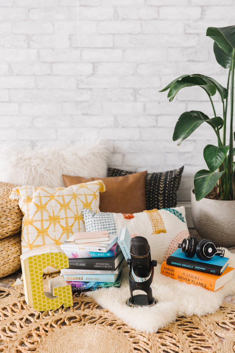 Pillows and books stacked on the floor in a podcast host's office