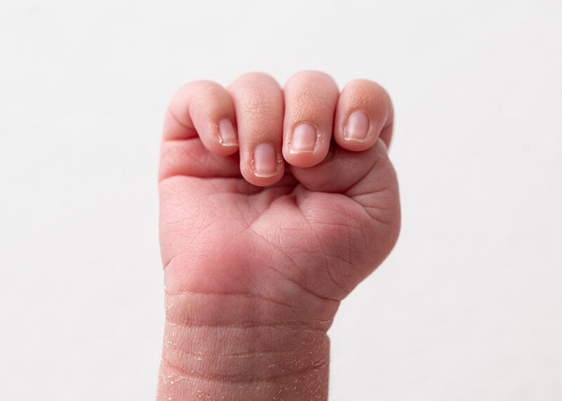 newborn-baby-clenched-fist-white-background