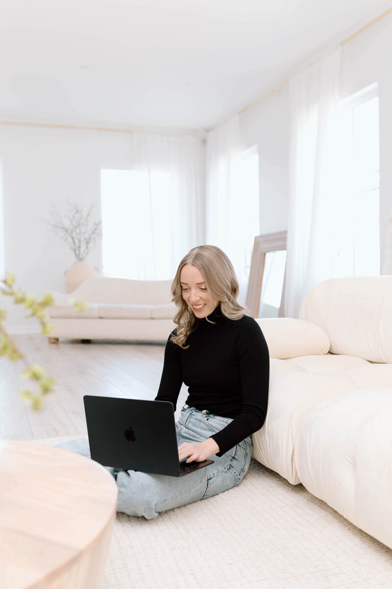 woman with laptop sitting on floor