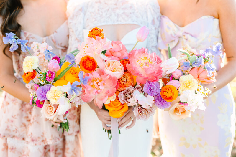 Close up photo of bride's and bridesmaids' colorful bouquets