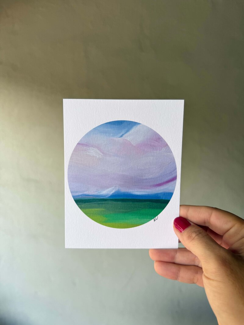 plum colored sky circle art print kristin vanderlip holding in hand