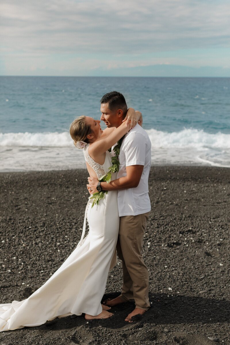Couple holding each other on beach in Hawaii
