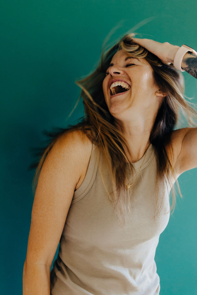 woman throwing her hair back and laughing