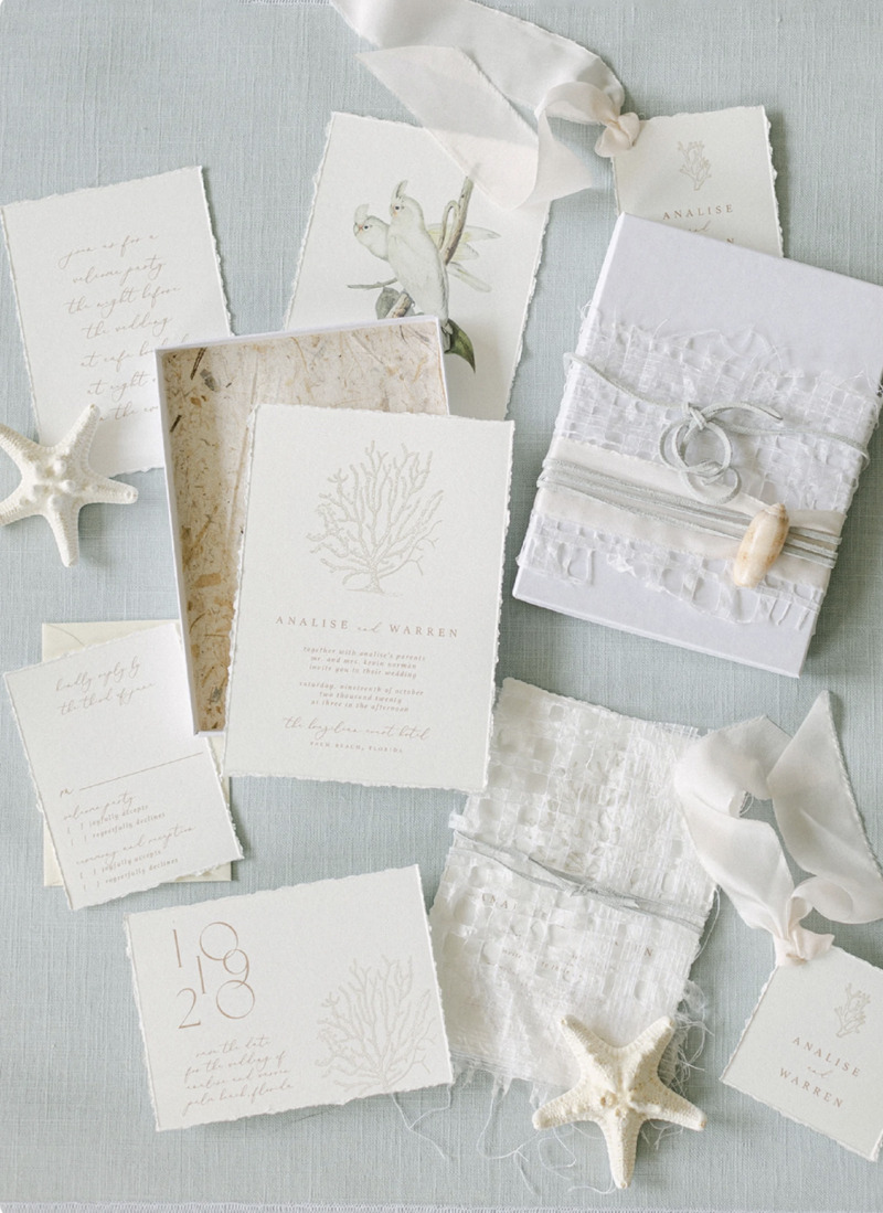 Soft blue linen flat lay mat styled with romantic paper goods and silk ribbon