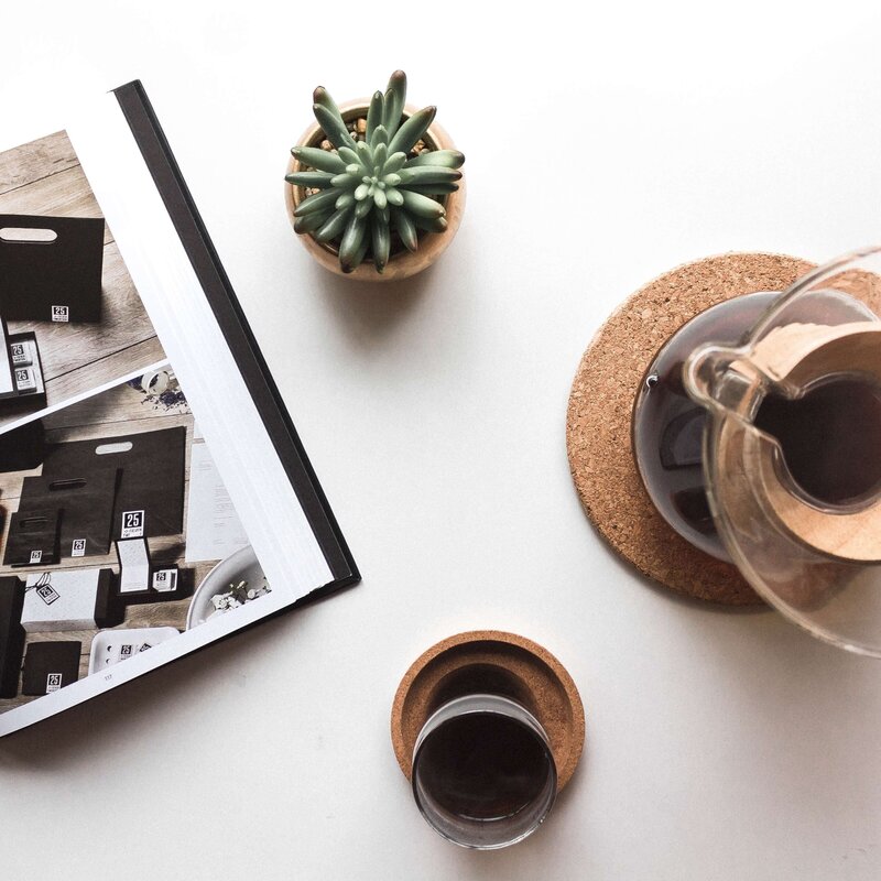 Desk flatlay with coffee and editorial photos.