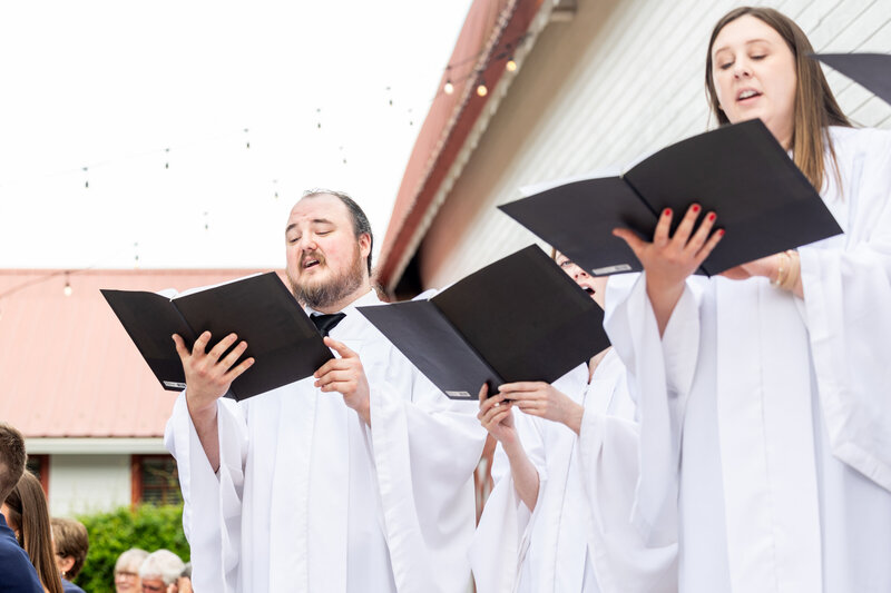 Spring wedding at WinMock at Kinderton, designed by Charming Carolina — choir singing a hymn during the outdoor ceremony on the East Terrace.