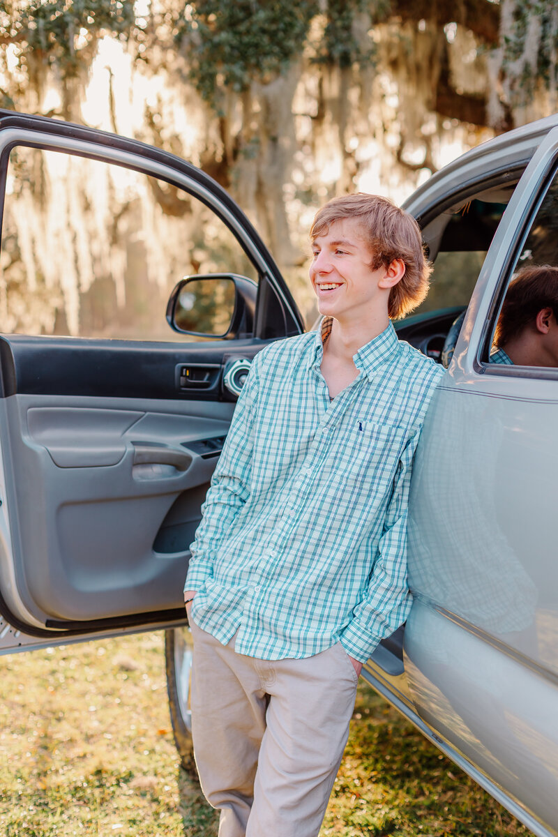 senior boy by his car with spanish moss