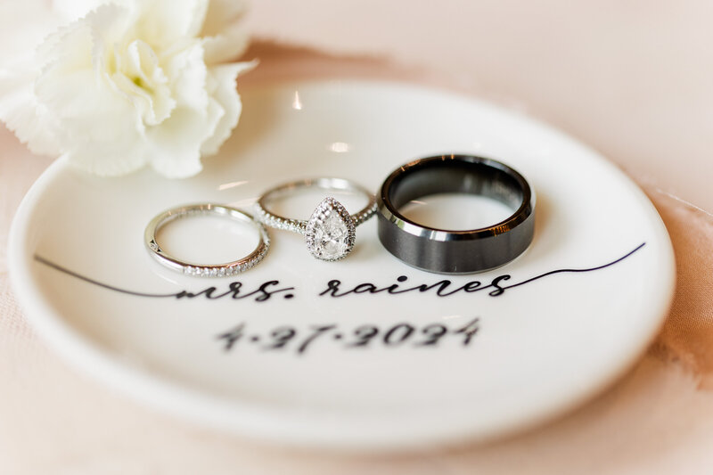 Wedding bands and engagement ring on a personalized stand with date and last name of Tampa wedding couple