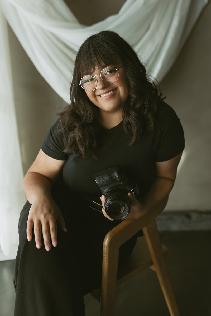 A professional headshot of Danielle Rose, a wedding and elopement photographer based in Wichita, Kansas, showcasing a warm smile and confident pose during her branding session.