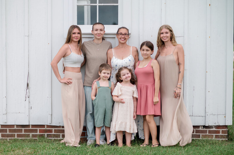 Kara Michelle’s six children standing together and smiling for a family portrait.