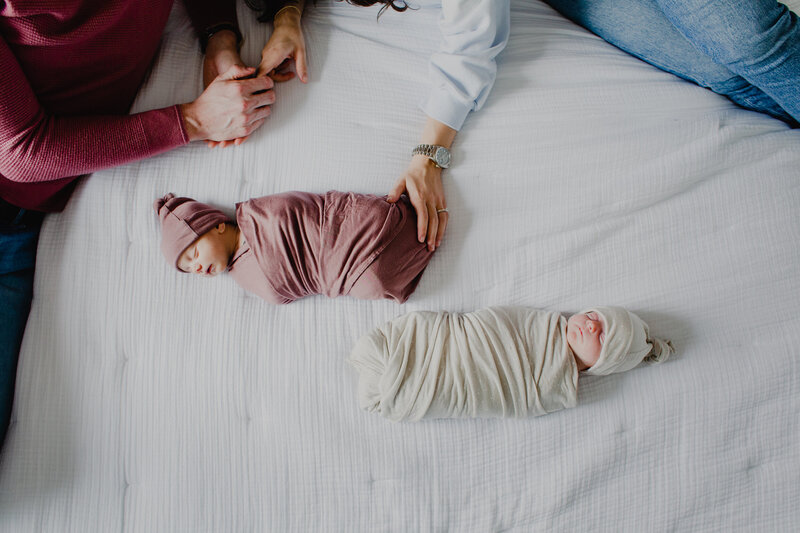 Overhead photo of a mother cradling her sleeping newborn daughter