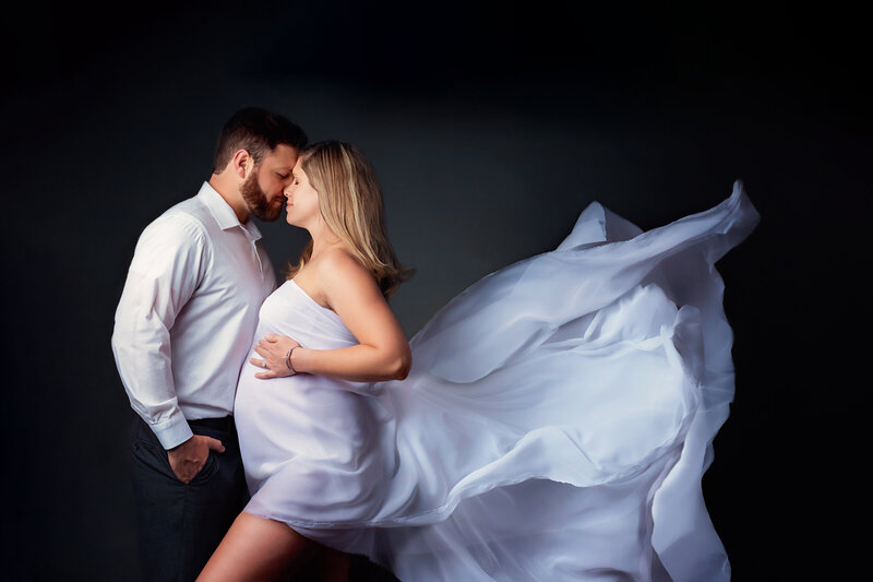 maternity couple with white flowy fabric