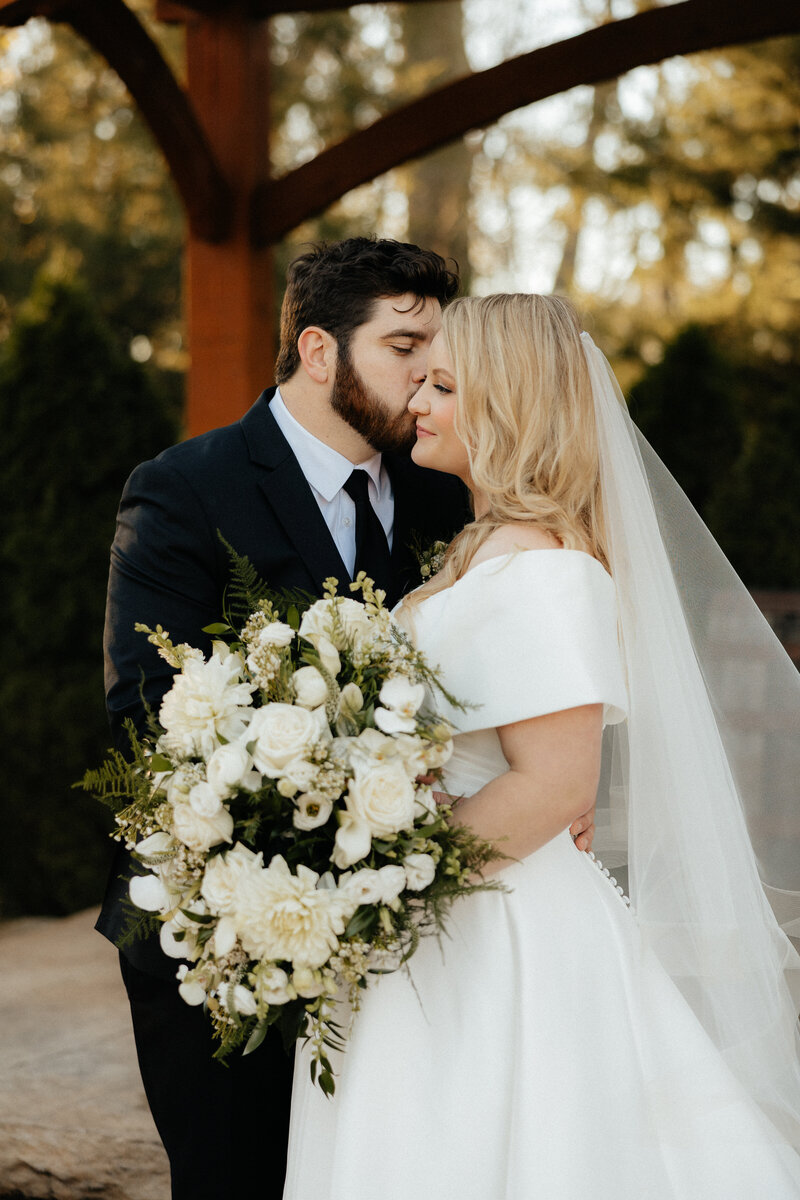 The groom kissing the bride's forehead.
