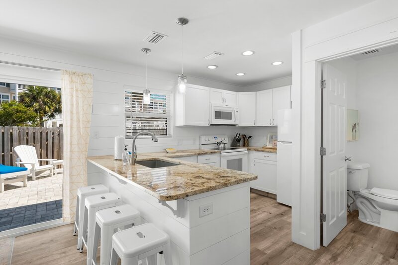 Fully equipped kitchen with granite countertops, white cabinetry, and modern appliances—ideal for cooking family meals on vacation.