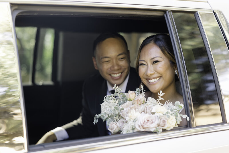 a couple on their wedding day taking a portrait in a field with the rolling hills in the distance.