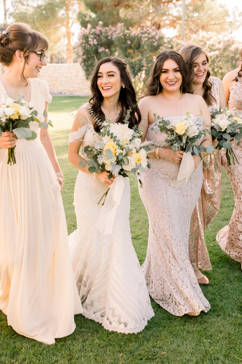 Bridesmaids laughing as they walk at Wedgewood Ocotillo Oasis wedding venue