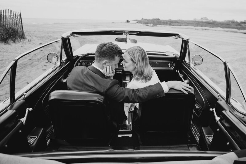 couple kissing in vintage getaway car after eloping