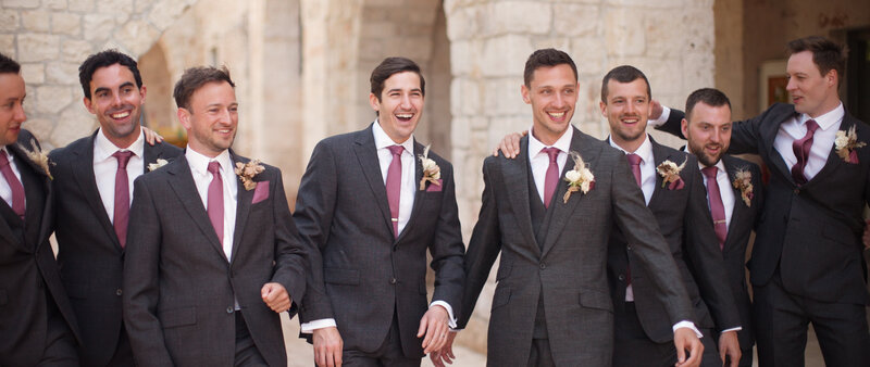 A screenshot from a destination wedding video featuring groomsmen and the groom
