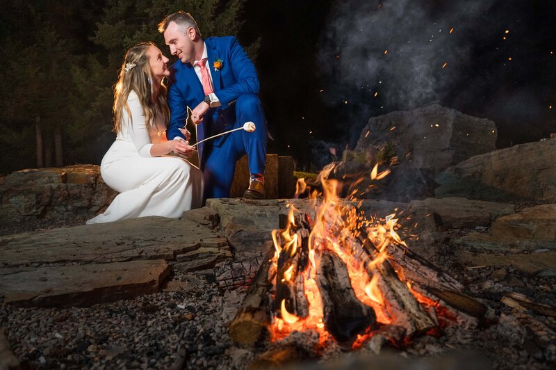 Bride and groom making smores on the fire at their wedding reception in Montana.
