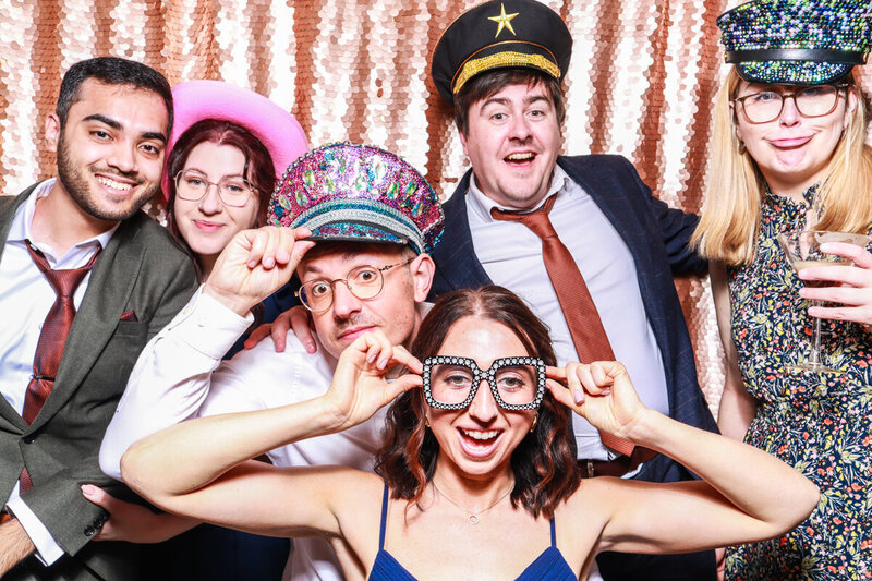 Large group of guests posign for an outdoor photo booth hire and rental for outdoor  weddings, corporate events, brand activations with mad hat photo booth rental