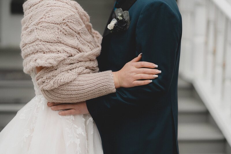 Torsos of wedding couple holding each other 