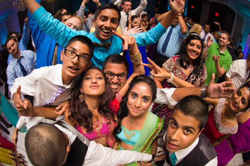 Group of friends letting loose on the dance floor, creating a fun and carefree wedding reception moment.