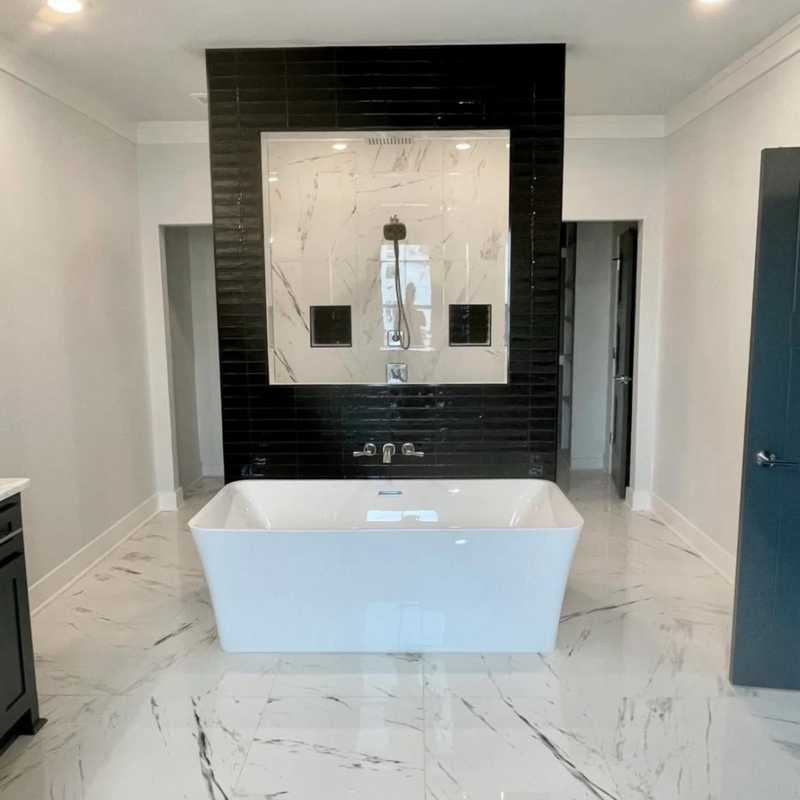 Free-standing tub with a detached custom shower head and backsplash.