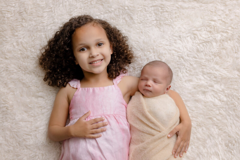 Newborn Photographer,  a young mother holds and admires her baby girl