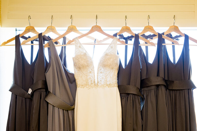 6-radiant-love-events-bridesmaids-bride-dresses-hanging-front-of-window-grey-dresses-romantic-elegant-timeless
