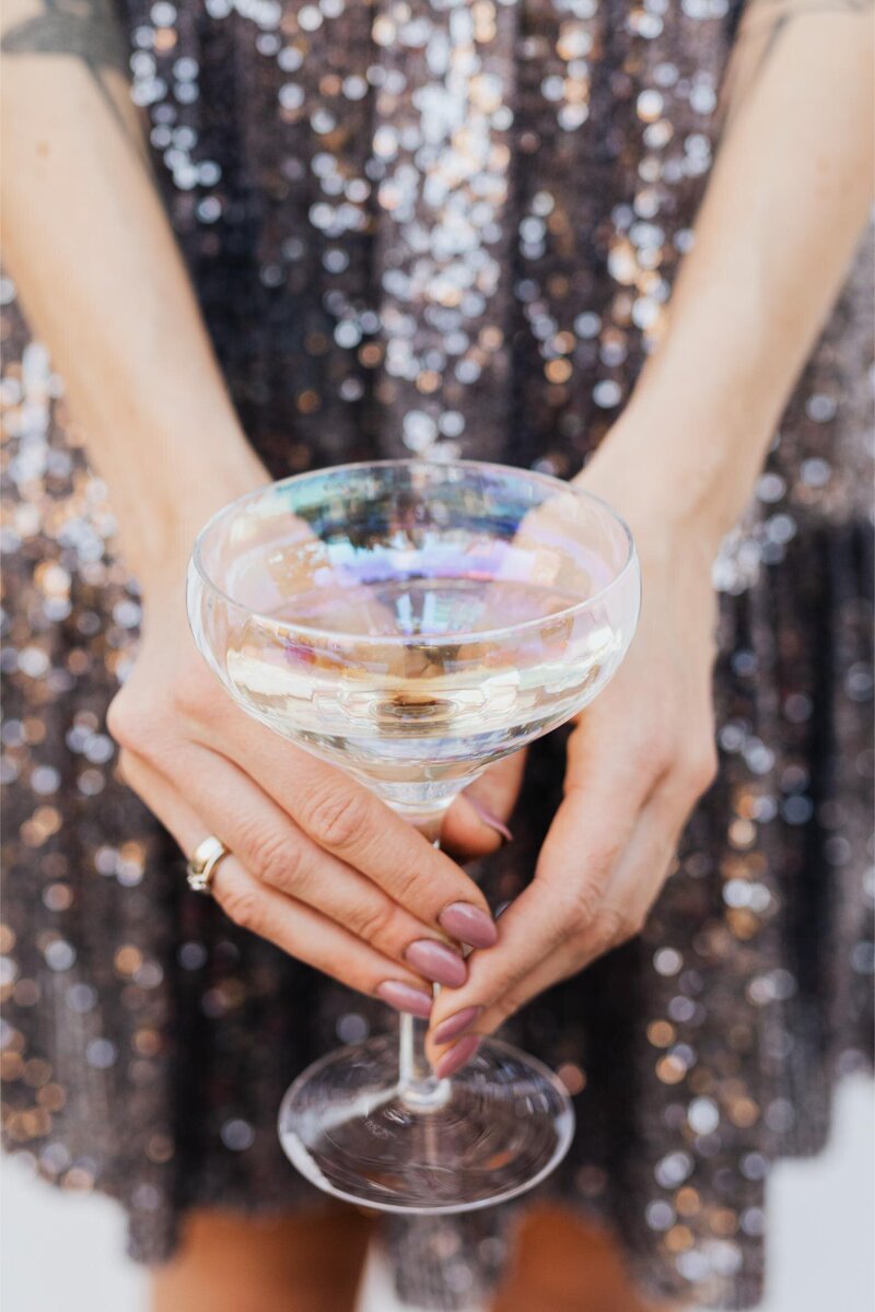 kaboompics_woman-in-a-sequin-dress-is-holding-a-glass-of-champagne-14707
