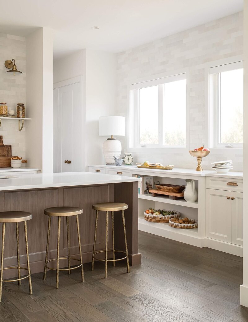 Kitchen and breakfast nook with white and dark wood cabinetry paired with brass and gold details.