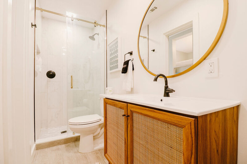 bathroom with walk in shower and round mirror