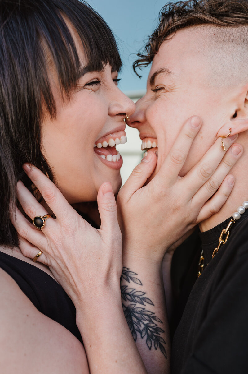 queer couple embracing and smiling
