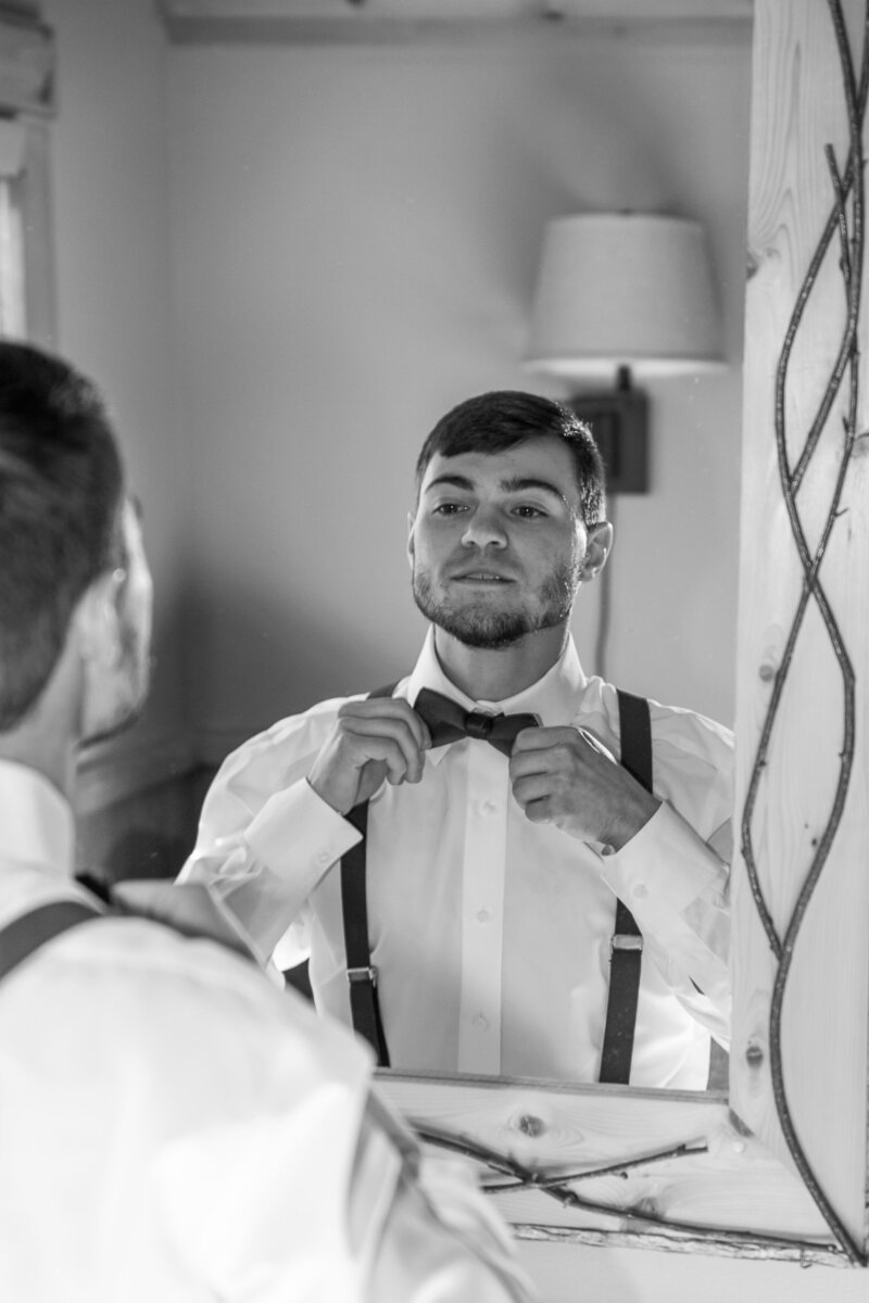 Groom fixing his tie | Rangeley, Maine Wedding Photography