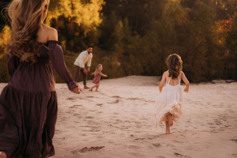 siblings running through the sand during a family session in The Woodlands, Texas