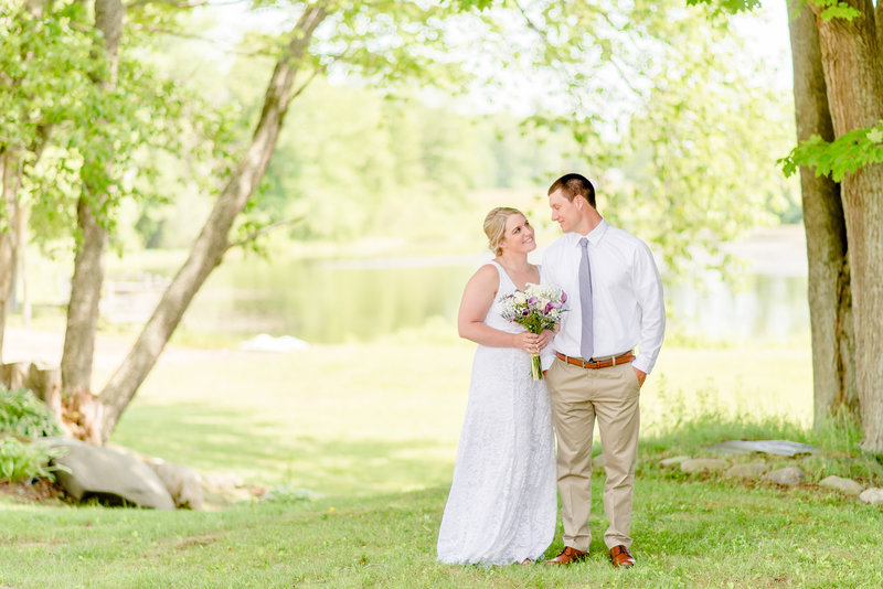 A bride a groom look at each other on a summer's day