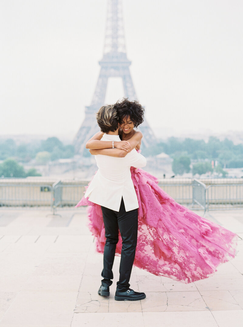 A bride and groom spin in front of the Eiffel tower.