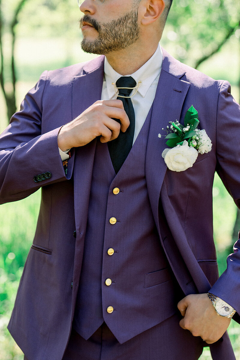 Tiffany Longeway Photography captures the elegance of a groom adjusting his tie in a striking purple suit at the luxurious Carneros Resort and Spa in Napa. The attention to detail and refined style exemplify the sophistication of a high-end wedding venue, ideal for couples seeking a chic and memorable celebration in the heart of California’s wine country.
