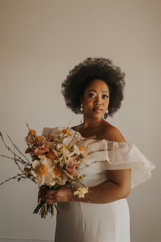 A person in a wedding dress holding a bouquet of flowers