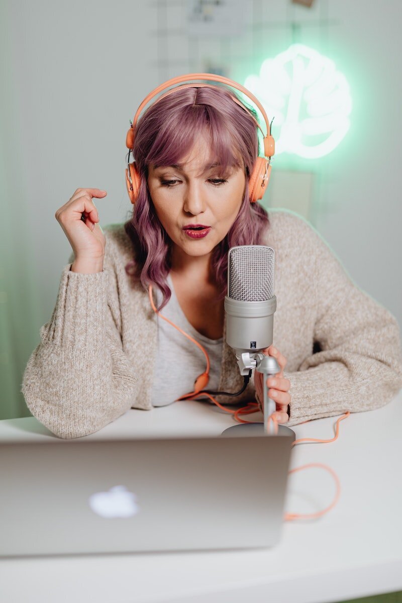 Podcaster wearing headphones and speaking into a microphone